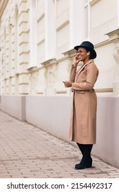 Woman Standing Straight, Smiling At Something, Using Earphones.