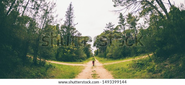 A woman stands at the\
crossroads of two forest roads. The girl at the crossroads. The\
choice of the path. Woman lost in the woods. The choice of ways to\
achieve the goal.