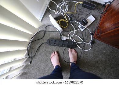 A Woman Stands In Front Of A Tangled Mess Of Electrical Cords And Plugs 