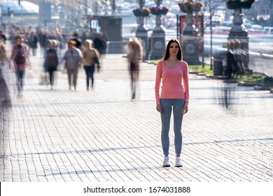 La mujer se para en medio de una calle concurrida