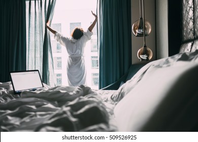 Woman Stands Near The Window In Hotel Room At Morning Time