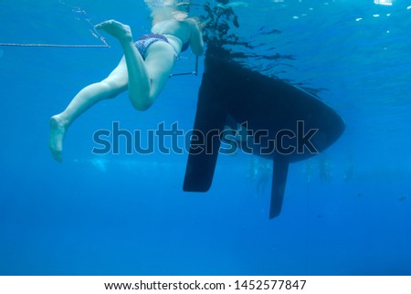 Woman stands on boat ladder for swimming in clear sea waters. Travel lifestyle, water sport outdoor adventure on family summer beach holiday. Relaxation.