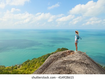 woman stands on a hill with stunning sea views. Travel, adventure, tourism concept.