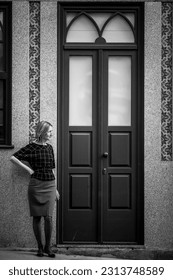A woman stands outside the front a house in Porto, Portugal. Black and white photo. - Shutterstock ID 2313748589