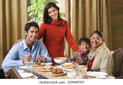 mulher fica sobre mesa de jantar com família sorridente