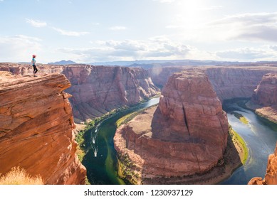 Woman Stands Over the Edge of Horseshoe Bend. Young woman enjoying view of Horseshoe bend, Arizona. Travel and adventure concept.