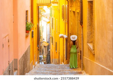 A woman stands at the top of a narrow hillside stairway in the colorful Italian village of Bellagio, on the shores of Lake Como in the Lombardy region. - Powered by Shutterstock