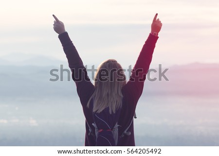 Woman Stands Victorious on Top of Mountain After Hike