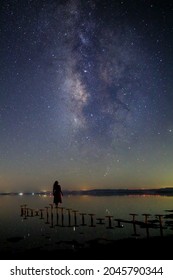 Woman Star Gazing At The Milky Way While STanding On Iron Steps In The Salton Sea