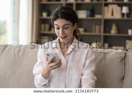 Woman staring at cellphone screen with mouth opened feels happy, read great message, got fantastic commercial proposal, received unbelievable social media news, huge discounts, sale-out offer concept