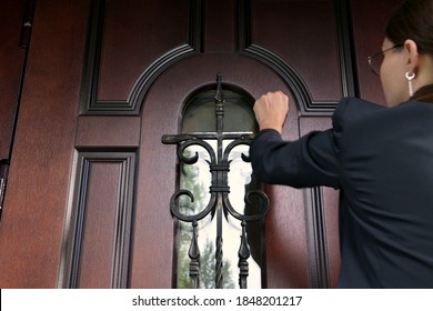 The woman and the state structure are persistently knocking on the door of a private house. Civil servant with a summons