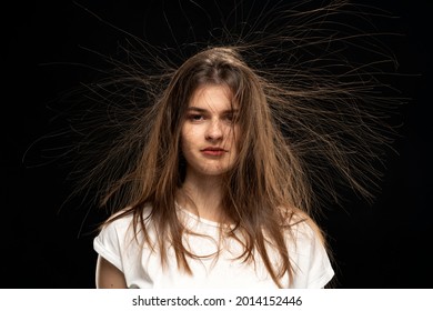 Woman with static electric hair isolated on black background.