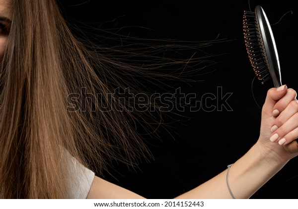 Woman with static electric hair isolated on\
black background.