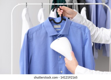 Woman Steaming Clothes At Dry-cleaner's