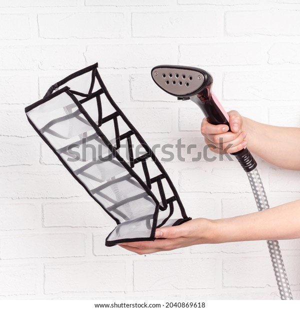 Woman steams a mesh organizer. Preparation\
for use. Mesh closet organizer drawer\
divider