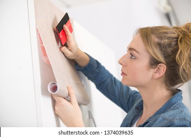 Woman Sticking Adhesive Veneer To Cupboard