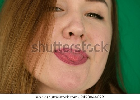 Woman sticking the tongue out. expression of emotions with hands unrecognizable people hands palms fingers close-up on green background chromakey feelings 