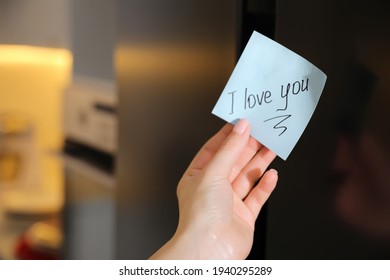 Woman With Sticky Note Saying I Love You Near Fridge Door, Closeup. Romantic Message