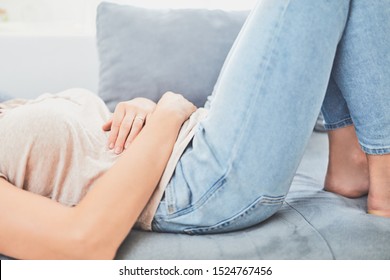 Woman With  Stomach Issues / Problems While Lying On The Couch.