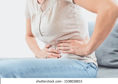 Woman With  Stomach Issues / Problems While Lying On The Couch.