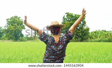 The woman stood back and raised her hands, enjoying the fresh air in the green fields. enjoying yoga, relaxing, feeling alive, breathing fresh air, calm and dreaming with closed eyes