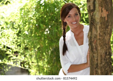 Woman stood touching tree