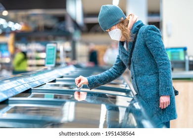 Woman In The Store Chooses Food From The Freezer