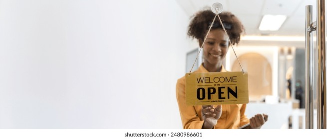 Woman store owner turning open sign broad through the door glass and ready to service. Small business woman owner turning the sign for the reopening - Powered by Shutterstock