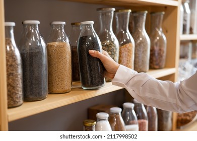 Woman in a store selling cereals by weight in an eco store. Trade concept without plastic packaging
