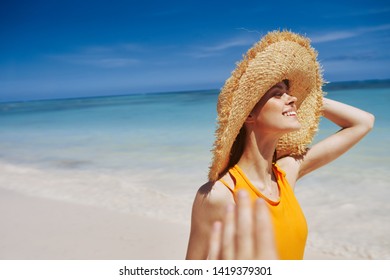  Woman in a straw hat and island ocean sand                         