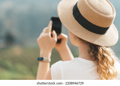 Woman In Straw Hat Making Photo Of Nature On Her Phone 