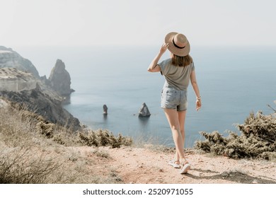 Woman in a Straw Hat on a Clifftop Overlooking the Sea - Powered by Shutterstock