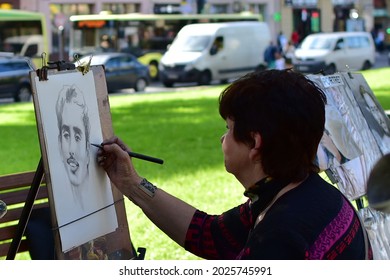 Woman Street Artist Paints A Portrait On White Sheet. Ukraine Lviv 13 August 2021