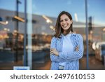 Woman in the street. Portrait of young happy woman on city street looking at camera. Confident stylish girl outdoor with copy space. Proud and satisfied woman standing on street.