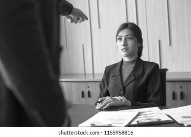 Woman With Stress Situation At Office. Boss Pointing Her Face With Angry Emotion. Black And White Tone.