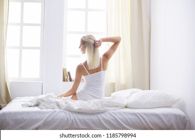 Woman stretching in bed after wake up, back view - Shutterstock ID 1185798994