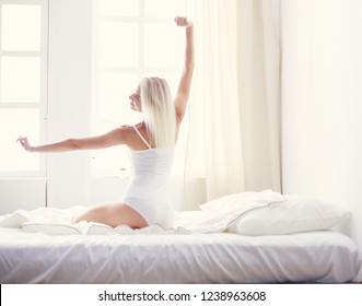 Woman stretching in bed after wake up, back view - Shutterstock ID 1238963608