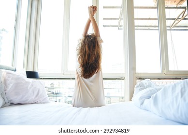 Woman Stretching In Bed After Wake Up, Back View