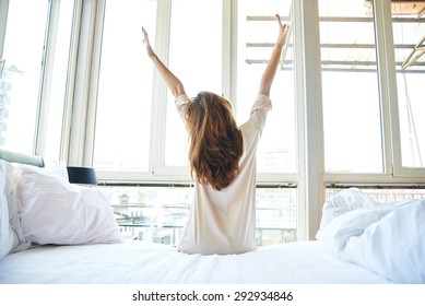 Woman stretching in bed after wake up, back view - Shutterstock ID 292934846