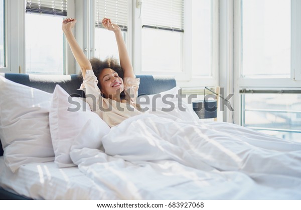 腕を上げてベッドに寝た女性 の写真素材 今すぐ編集