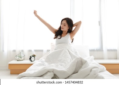 Woman stretching happy and relaxed after wake up in the morning at home - Shutterstock ID 1457404832