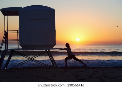 Woman Stretching Leg Muscle Before Early Morning Run Workout On Beach