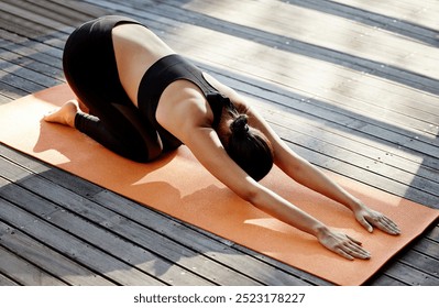 Woman, stretching and mat on deck for yoga, fresh air and meditation for mental health. Girl, breathing exercise and childs pose at home for pilates, zen or calm to align chakra for spiritual healing - Powered by Shutterstock