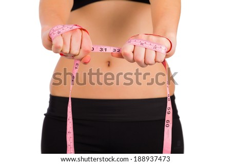 Woman stretching measuring tape as concept of gym, diet resulting weight loss.
