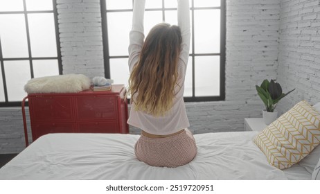 Woman stretching on bed in cozy bedroom with light wooden walls, large windows, and indoor plants, presenting a peaceful morning routine. - Powered by Shutterstock