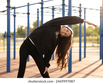 Woman Stretching Outdoor  in the Morning Sun doing her daily sport routine - Powered by Shutterstock