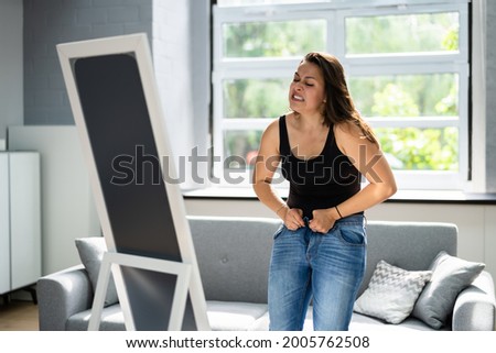 Woman Struggling With Tight Jeans. Weight Gain