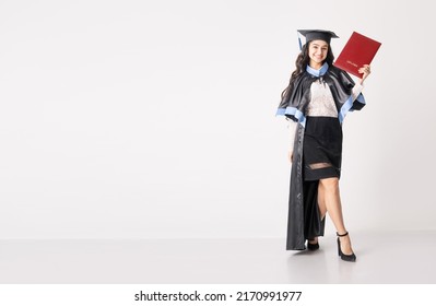 Woman student with diploma on white background with copy space. University graduate indian race woman wearing academic regalia and holding red diploma. - Shutterstock ID 2170991977