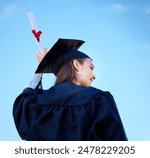 Woman, student and diploma at outdoor graduation, blue sky and proud of education celebration. Female person, back and degree at college or university for achievement, graduate and learning award