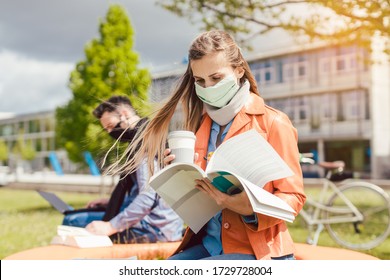 Woman Student On College Campus Learning Wearing Face Mask While Working On Her Laptop